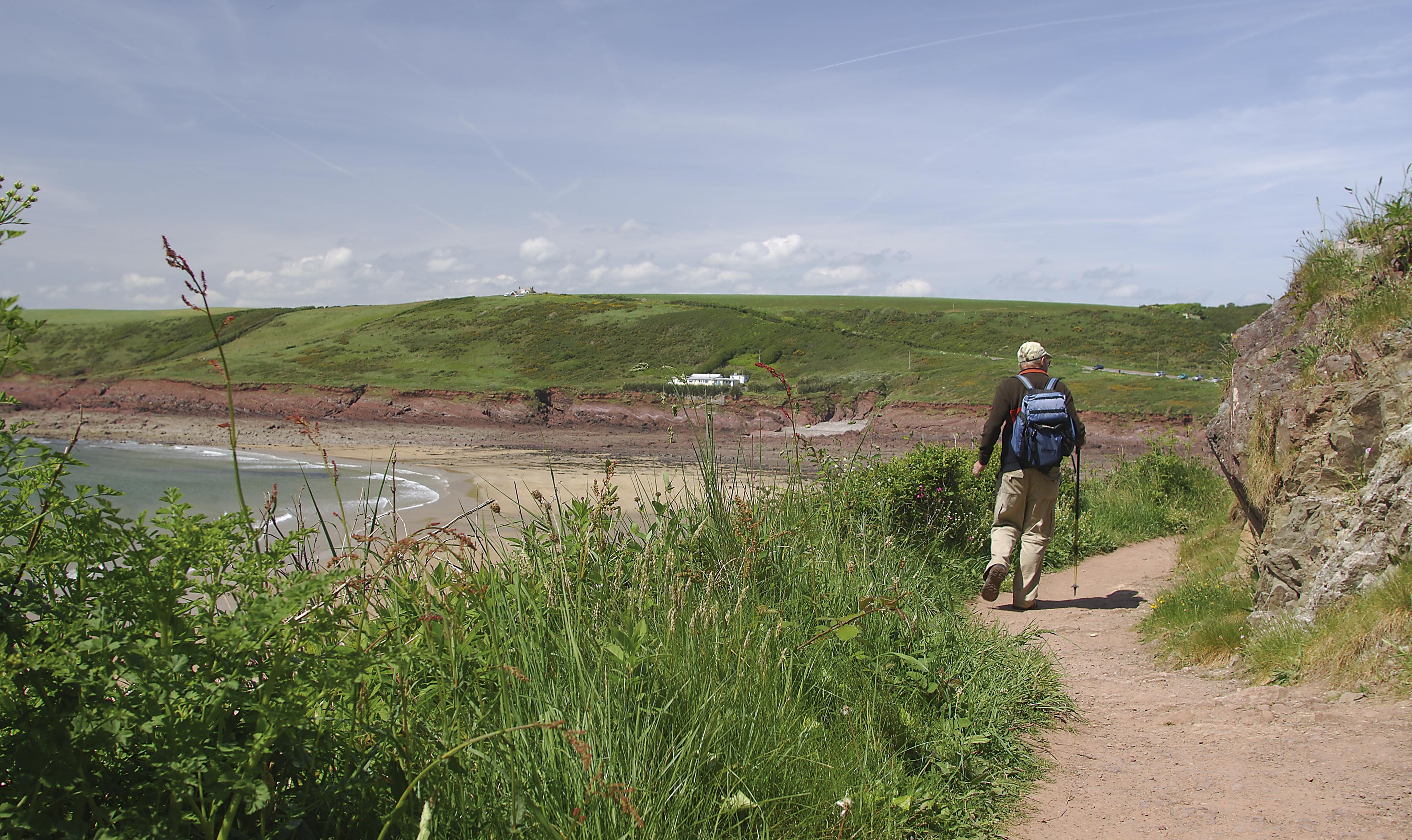 Walker on the Pembrokeshire Coast Path approaching Manorbier