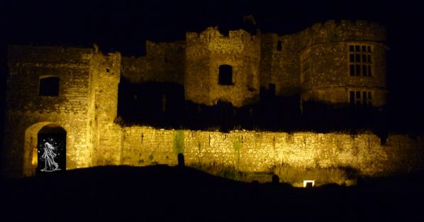 Castle in darkness lit up by a single light with an image of a white spirit in a doorway