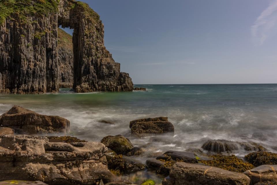 Limestone arch with almost perfect rectangular gap through the middle of it. Location is Church Doors, Pembrokeshire